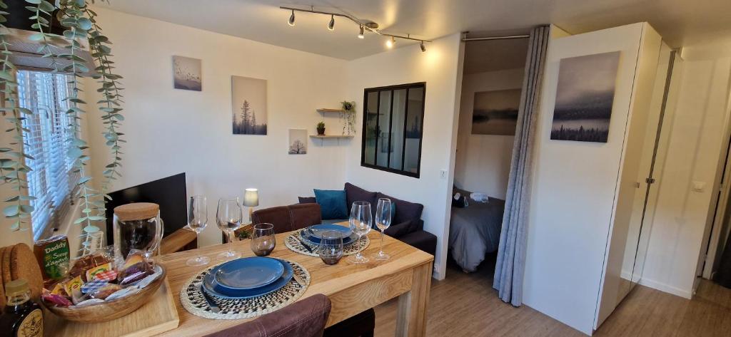 a dining room with a table with wine glasses on it at Beau studio très calme, parking privée gratuit, Netflix in Linas