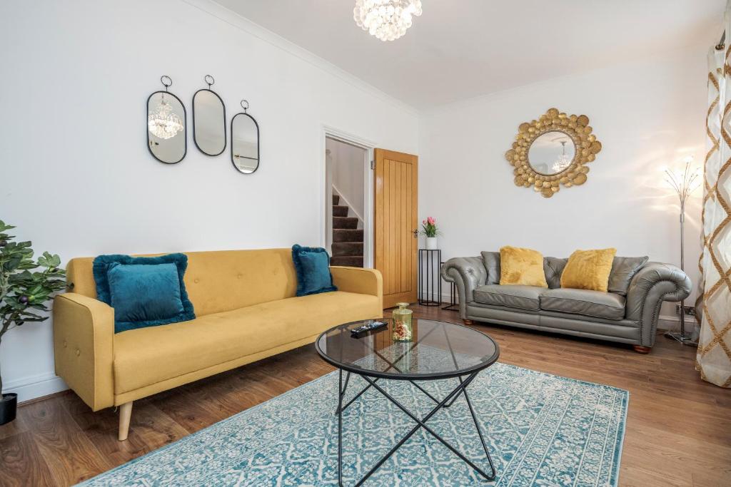 uma sala de estar com um sofá amarelo e uma mesa em Entire Lovely family home with Wi-Fi, Netflix, self check-in em Londres
