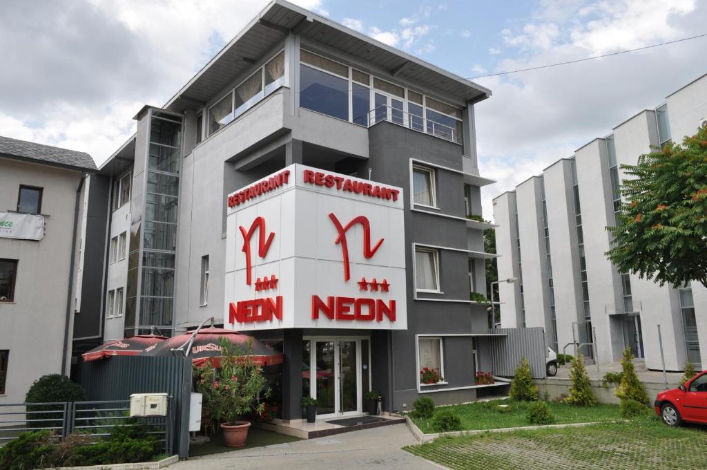 a building with a sign for a new median at Hotel Neon in Timişoara