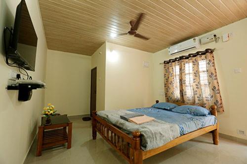 a bedroom with a bed with a ceiling fan at The Little Prince - Mangalore Beach Homestay in Mangalore