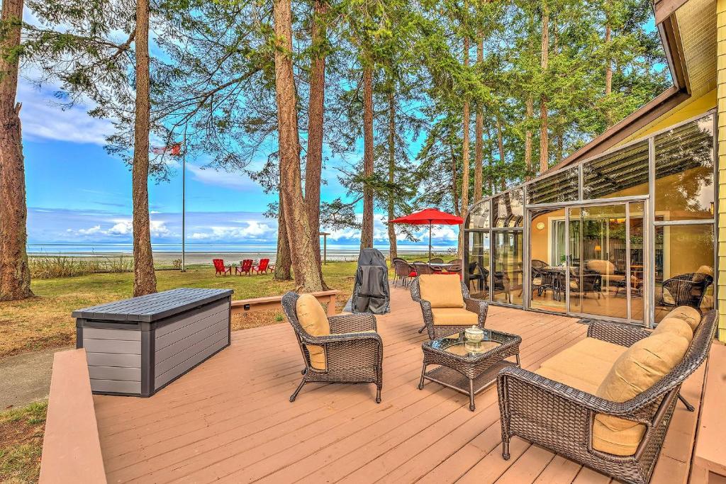 a wooden deck with chairs and a table at Kye Bay Beach House in Comox