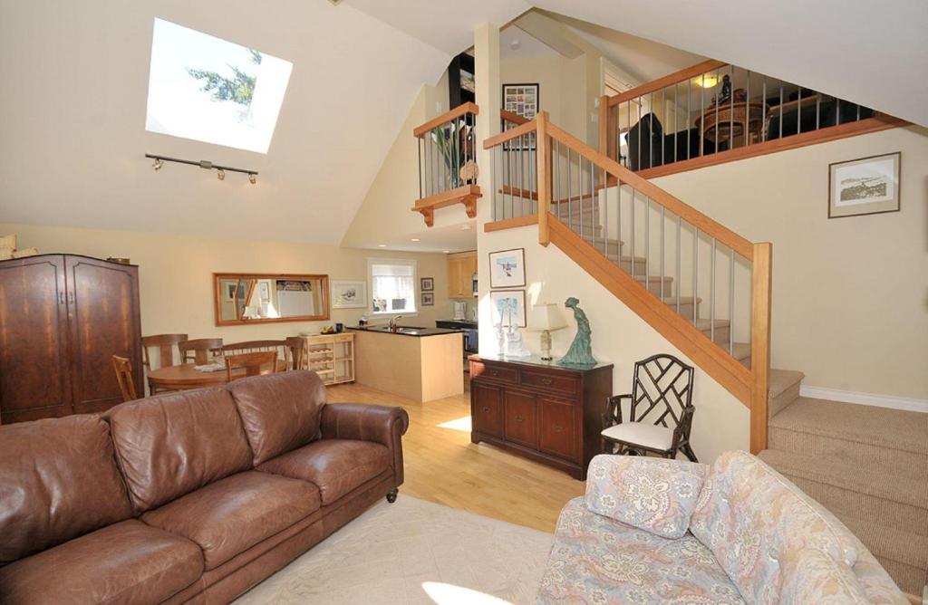 a living room with a couch and a staircase at Heron View Cottage in Sidney