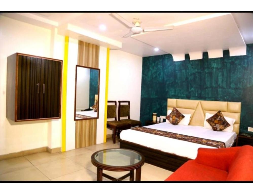 a bedroom with a bed and a couch and a table at Hotel Kirandeep, Agra in Agra