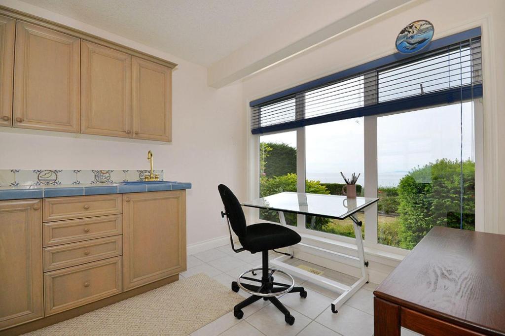een keuken met een bureau en een stoel voor een raam bij Columbia Beach House in Parksville