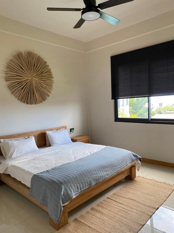 a bedroom with a bed with a ceiling fan at Green Creek Villa in Flic-en-Flac