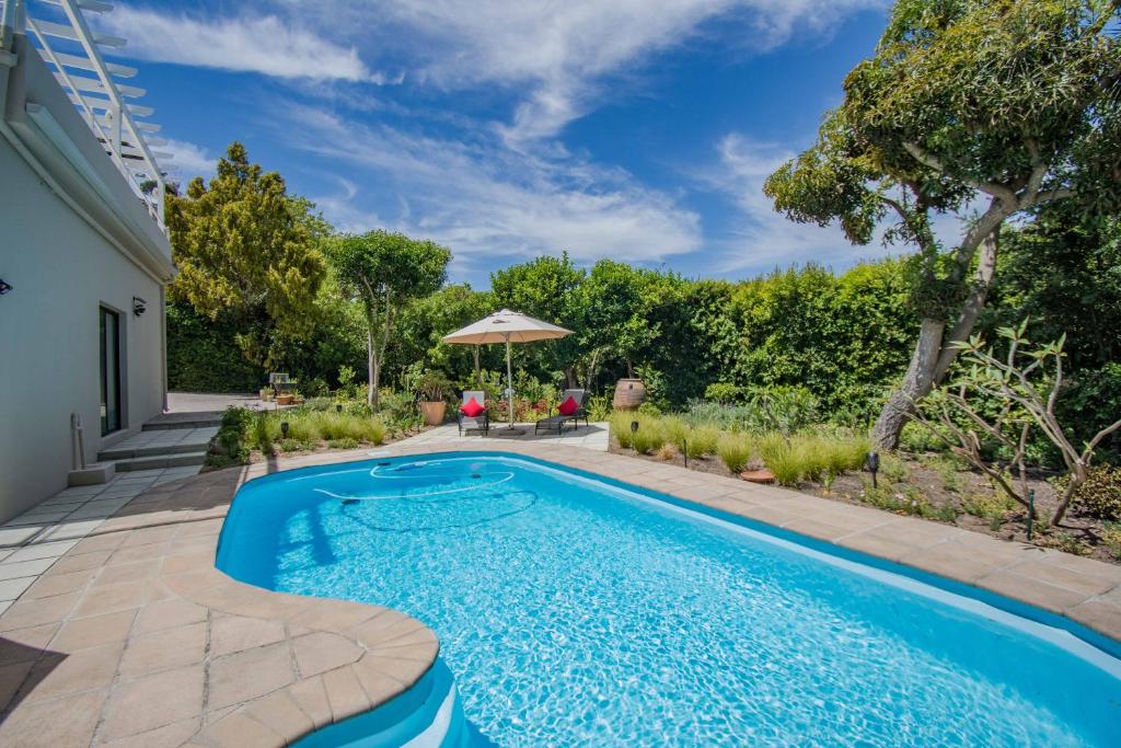 a swimming pool in the backyard of a house at Garden- Pool flat with Solar Electricity in Somerset West