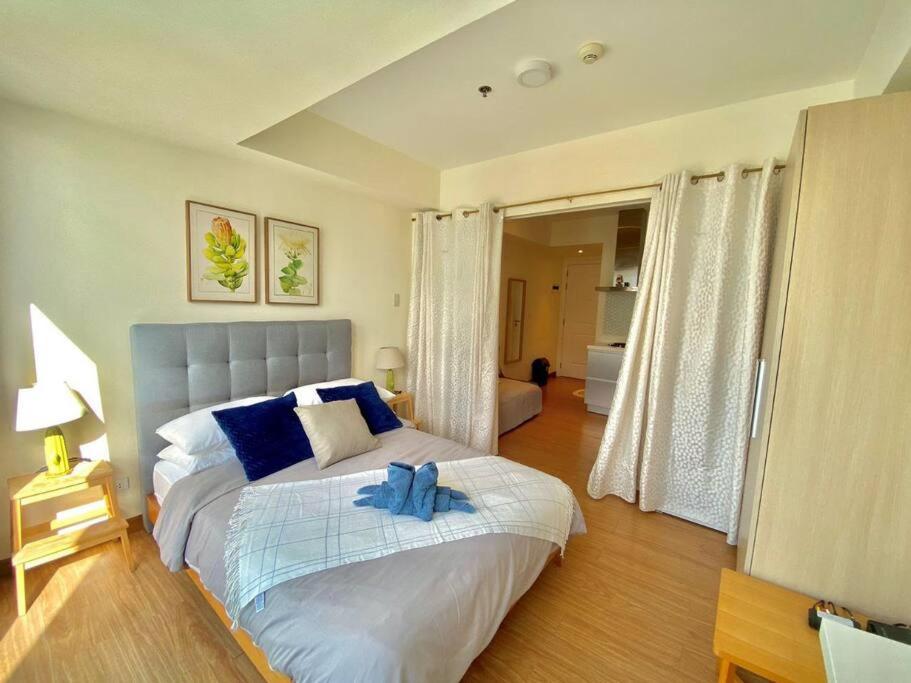 Un dormitorio con una cama con una toalla azul. en Homey & Comfy 1BR Unit at Azure, en Manila