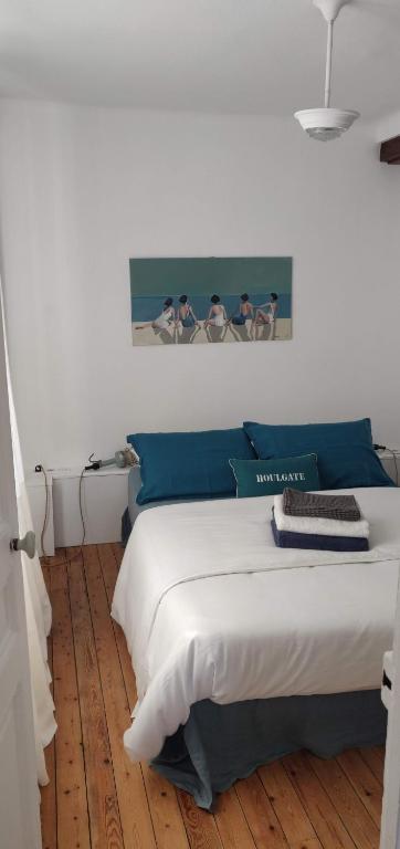 a bedroom with a large bed with blue pillows at Escapade de charme les pieds dans l'eau in Houlgate