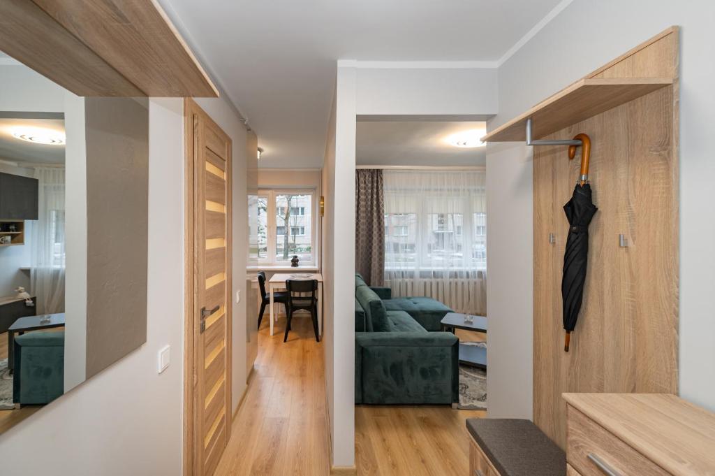 einen Flur, der zu einem Wohnzimmer mit offener Tür führt in der Unterkunft Modern n' lovely apartment by Polo Apartments in Kaunas