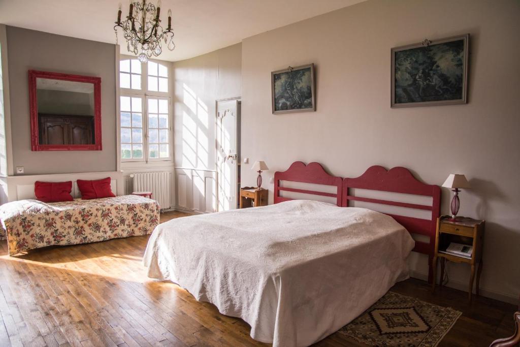 a bedroom with two beds and a chandelier at Chambres d'hôtes de charme Le Pradel in Monceaux-sur-Dordogne