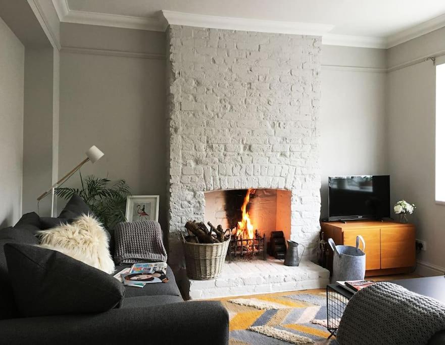 a living room with a fireplace and a couch at Flamingo House in Whitstable