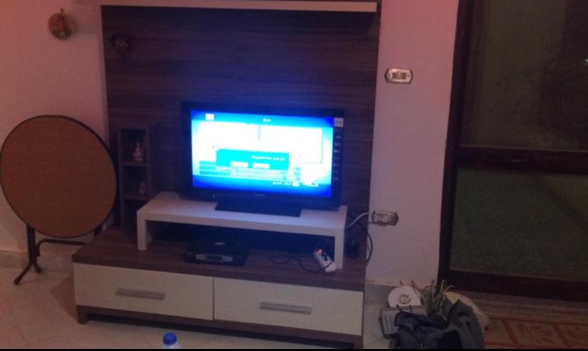 a tv sitting on a stand in a living room at Small apartment with Garden in Cairo
