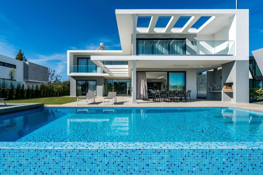 uma casa moderna com uma piscina em frente em Colinas do Golfe Vilamoura Sun by SAPvillas em Vilamoura