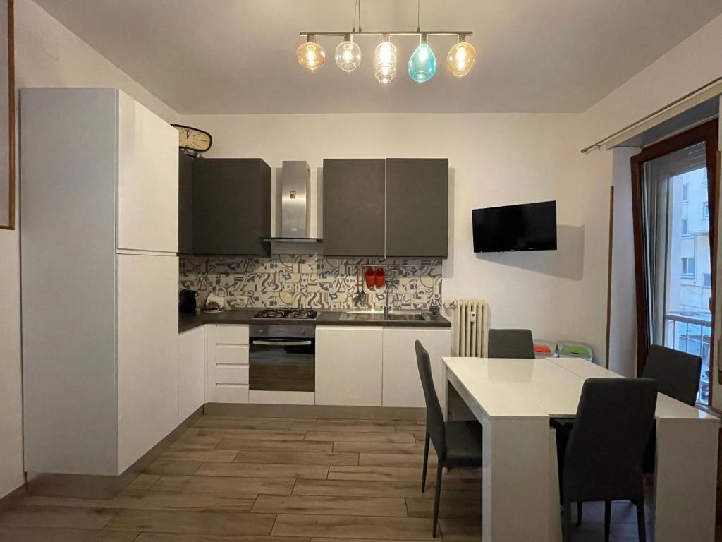 a kitchen and dining room with a table and a refrigerator at EasyRome - Appartamento a Roma San Paolo in Rome