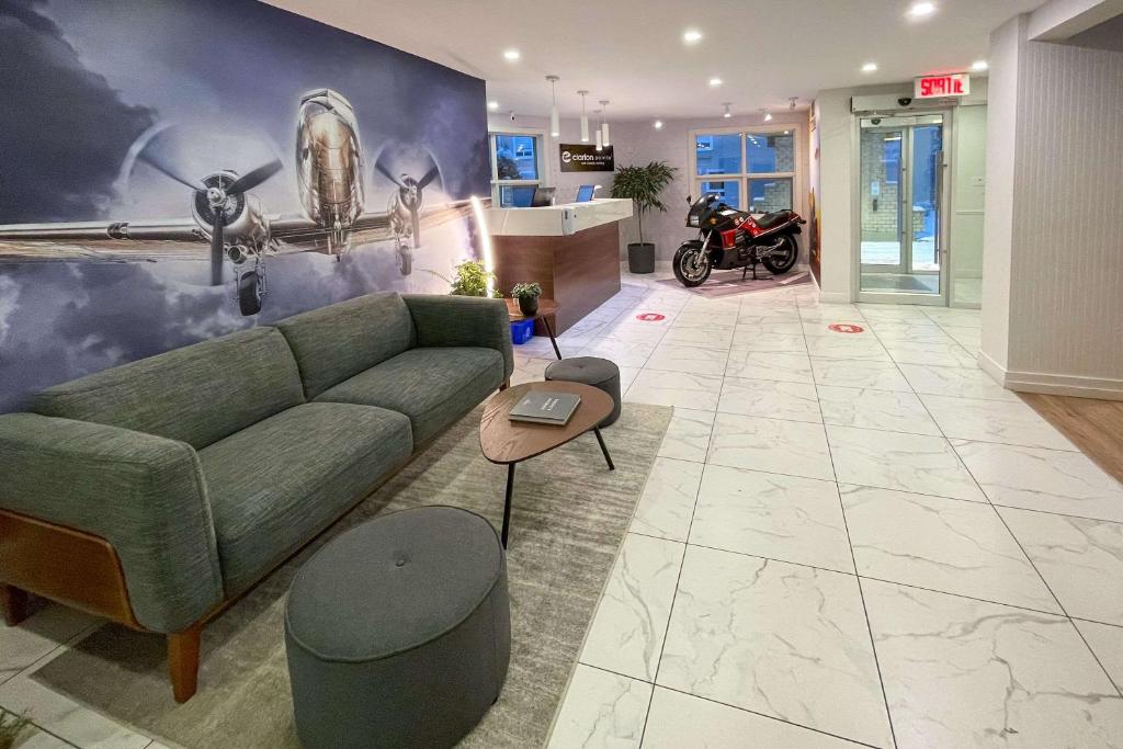 Clarion Pointe Quebec Airport في مدينة كيبك: غرفة معيشة مع أريكة خضراء ودراجة نارية