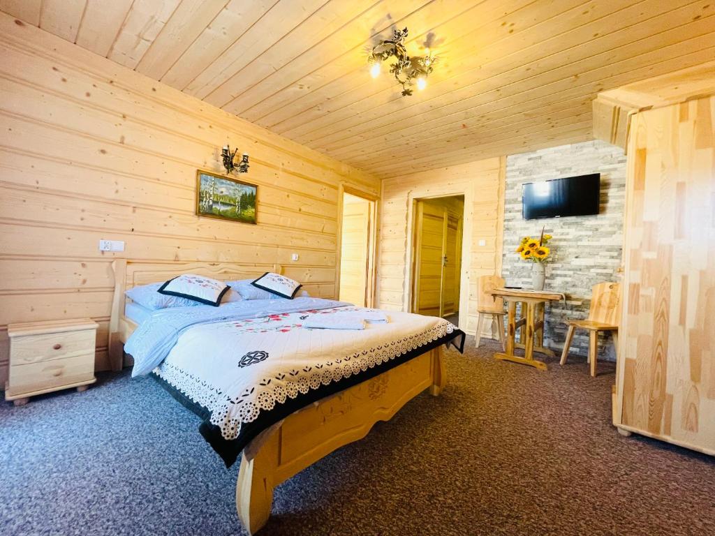 een slaapkamer met een bed in een houten kamer bij U Maćka in Poronin
