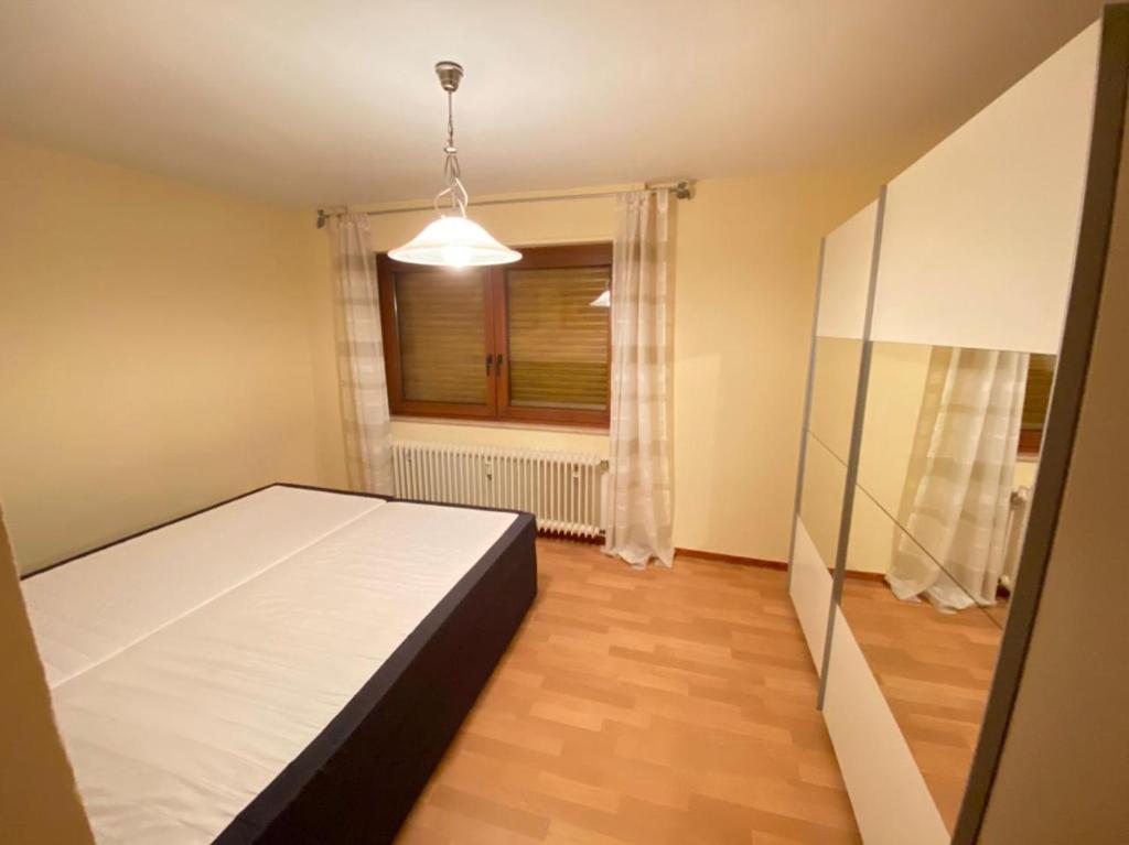 a bedroom with a white bed and a window at Schöne Ferienwohnung in Laurenburg in Laurenburg