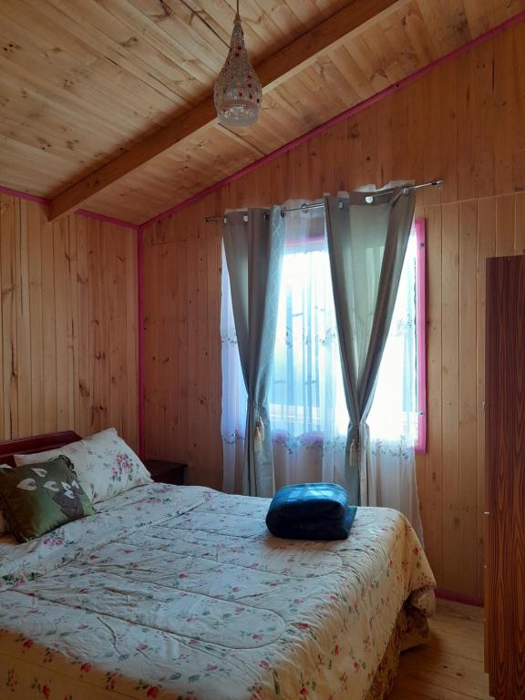 a bedroom with a bed and a window with curtains at Camping las islas in Panimávida
