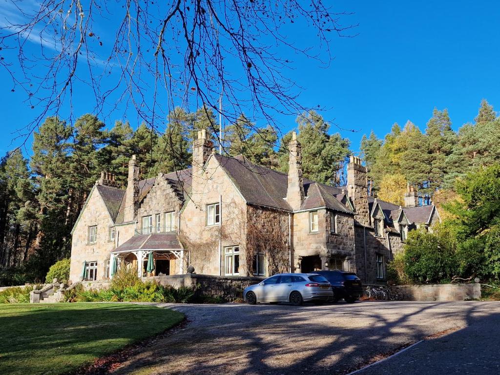 uma casa grande com um carro estacionado em frente em Cambus O' May Hotel em Ballater