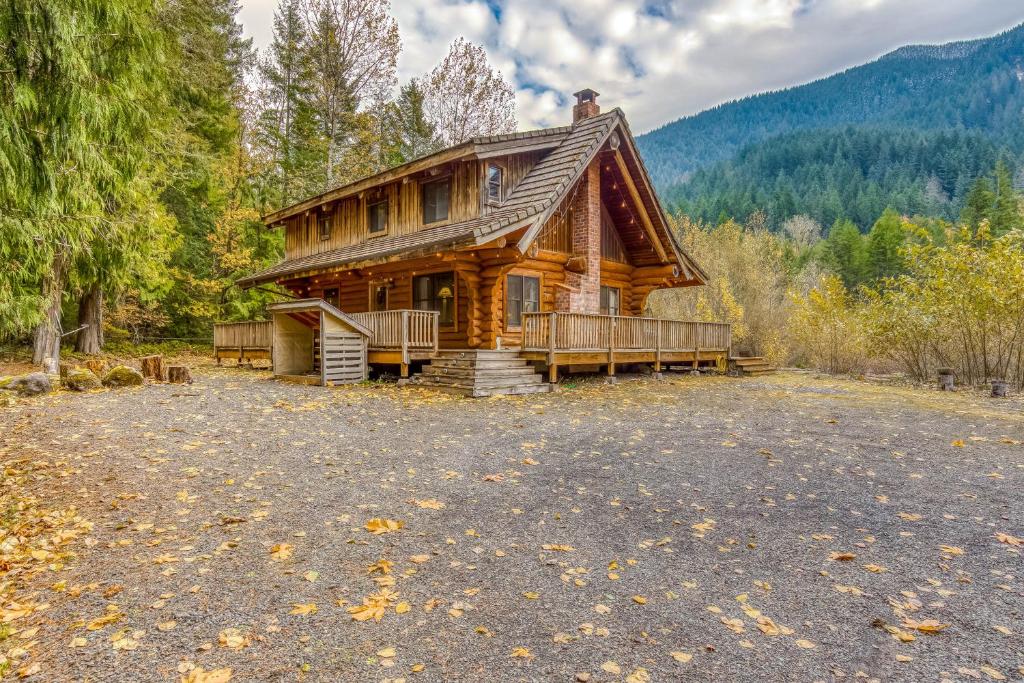 a log cabin in the woods with a large yard at Sandy River Relaxation in Rhododendron