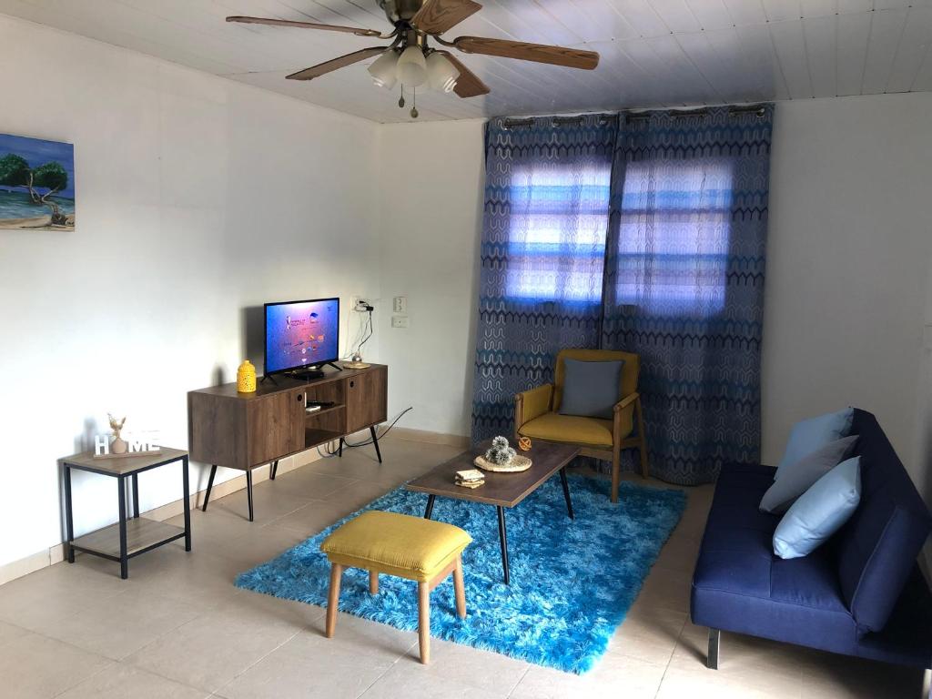 a living room with a blue couch and a tv at Local Home Aruba in Catiri