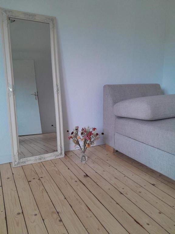 a living room with a couch and a mirror at TannenQuartier - Ihr Ferienhäuschen in Groß Grönau