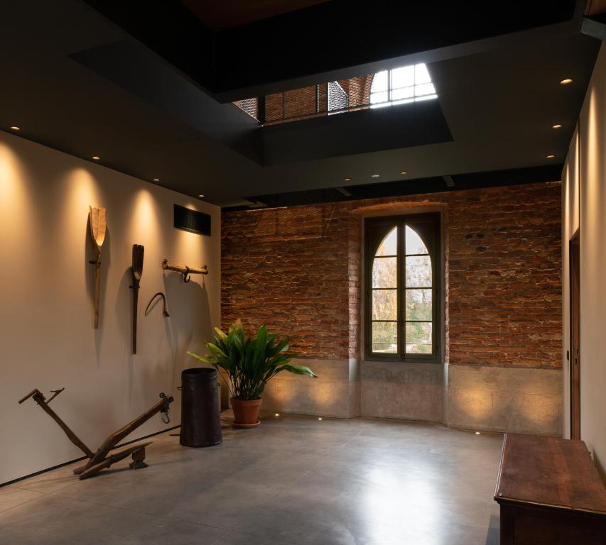 Cette grande chambre est dotée d'un mur en briques et d'une fenêtre. dans l'établissement Agriturismo Padernello, à Borgo San Giacomo