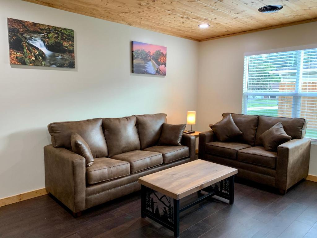 uma sala de estar com dois sofás de couro e uma mesa de centro em High Valley Apartments em Pigeon Forge