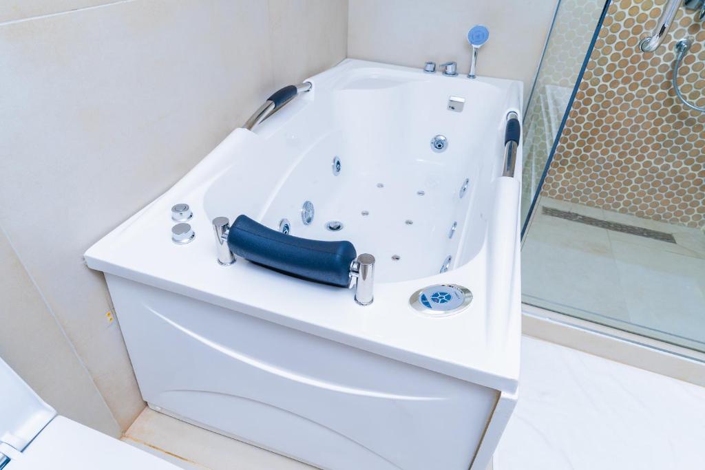 a white bath tub with a blue belt on top at Terraform Hotel in Lagos