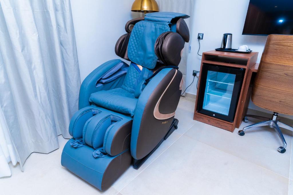 a blue gaming chair in a room with a desk at Terraform Hotel in Lagos