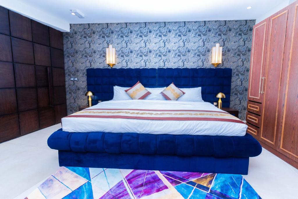 a bedroom with a blue bed with a blue headboard at Terraform Hotel in Lagos