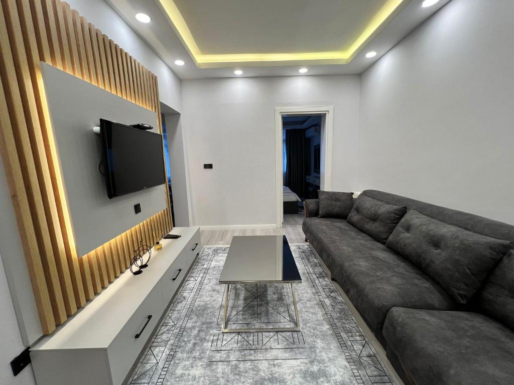 a living room with a couch and a tv on a wall at Kule Apart in Istanbul