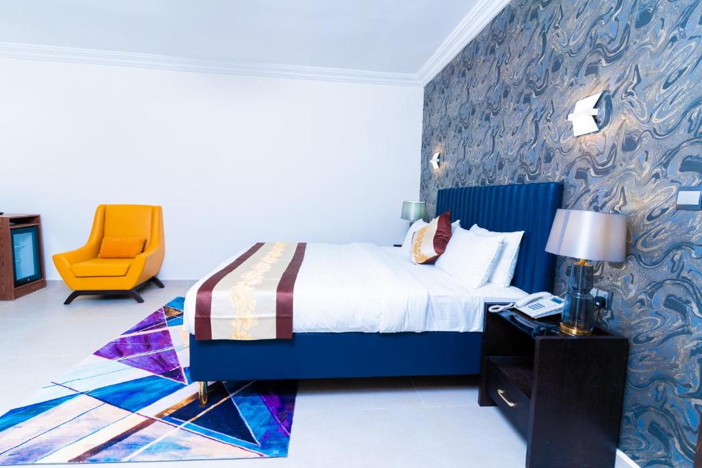 a bedroom with a bed and a yellow chair at Terraform Hotel in Lagos