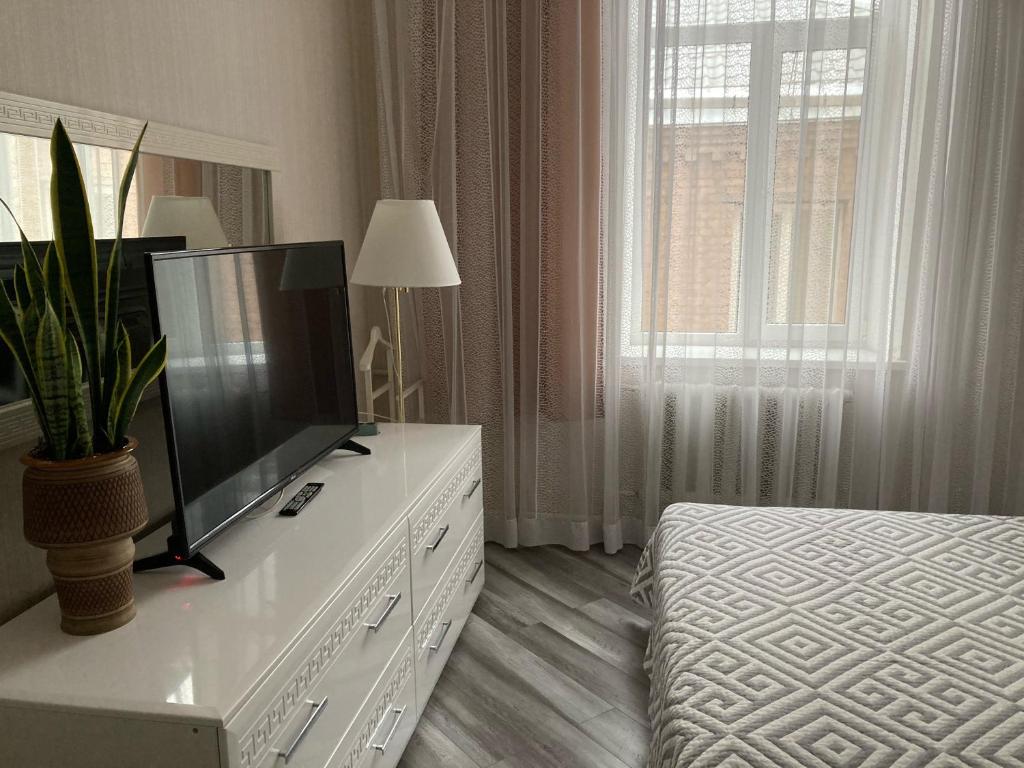 a living room with a tv on a white dresser at Apartment Sobornaya 54 in Vinnytsya