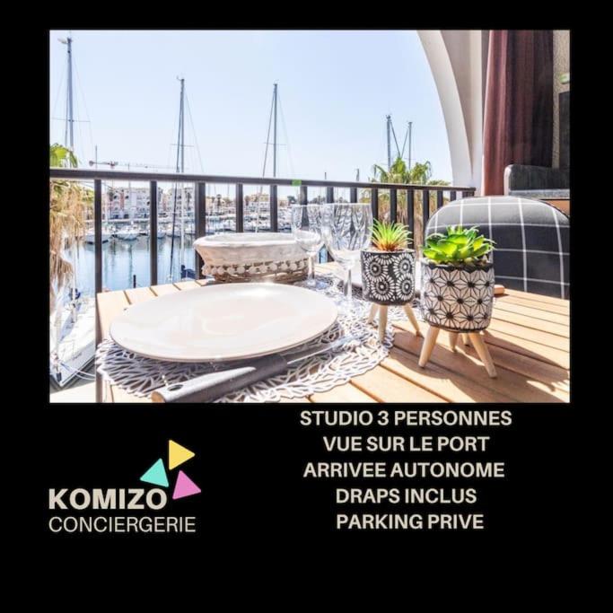 une publicité pour une terrasse avec une table et des chaises sur un balcon dans l'établissement La Brise Marine. Vue Panoramique Port de Plaisance, à Leucate