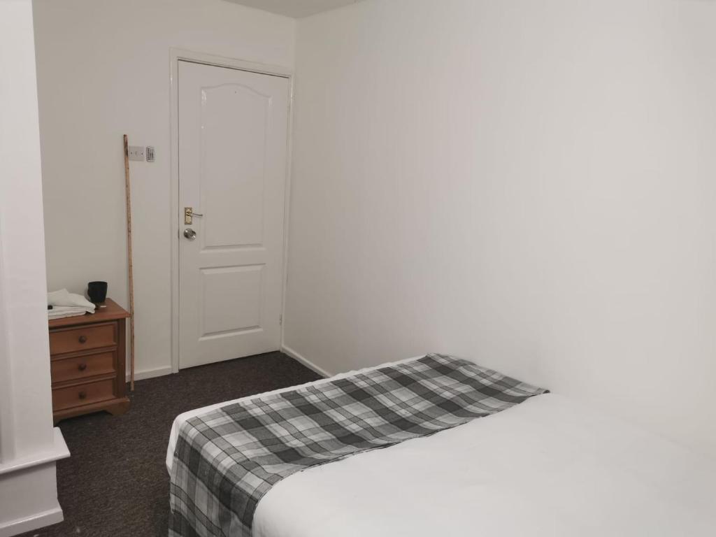 1 dormitorio con 1 cama, vestidor y puerta en Macpherson House, en Luton