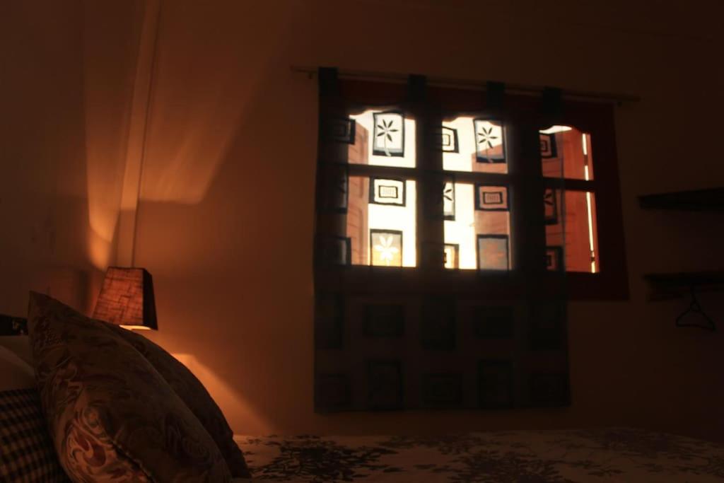 a window in a room with a bed and a lamp at Asunfou : Appartement d'apaisement in Mirleft