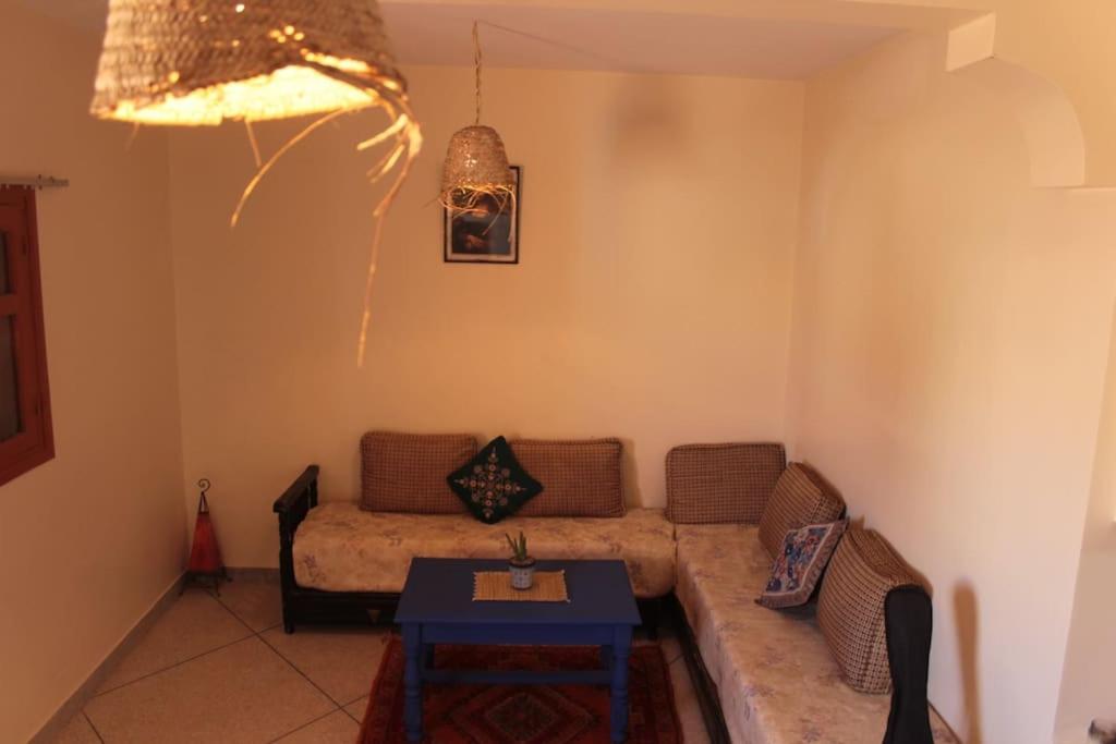 a living room with a couch and a table at Asunfou : Appartement d'apaisement in Mirleft