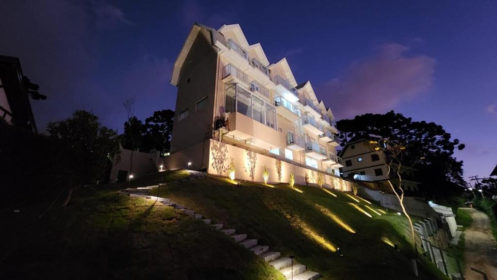 a building with lights on the side of it at night at Pousada Kaliman Luxo in Campos do Jordão