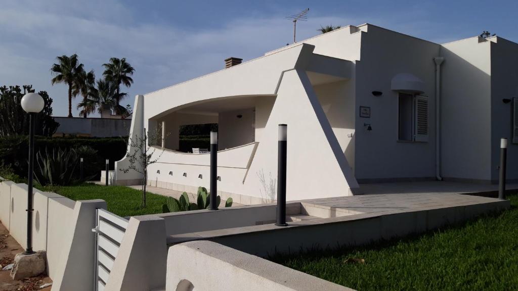 una casa blanca con una rampa en un patio en Villa NinniTina, en Noto