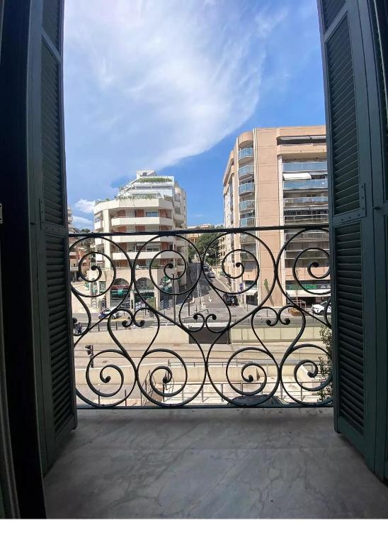 an open door to a balcony with a view of buildings at studio à 2 mn à pied de la plage in Nice