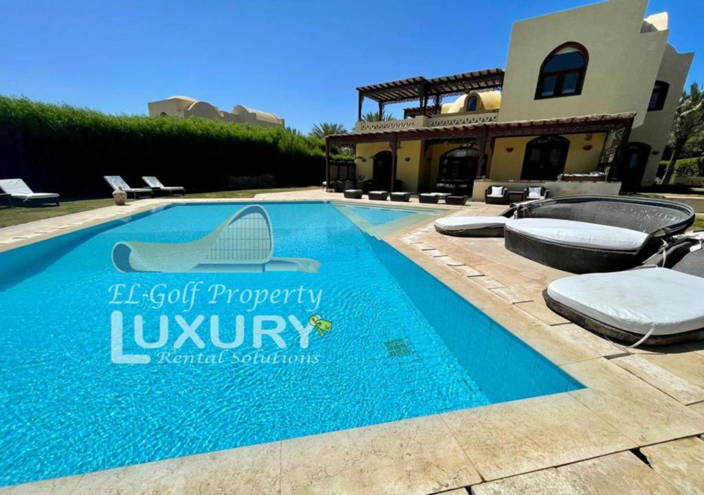 a swimming pool in front of a house at Villa 4 Bed Rooms-North Golf-GN24 in Hurghada