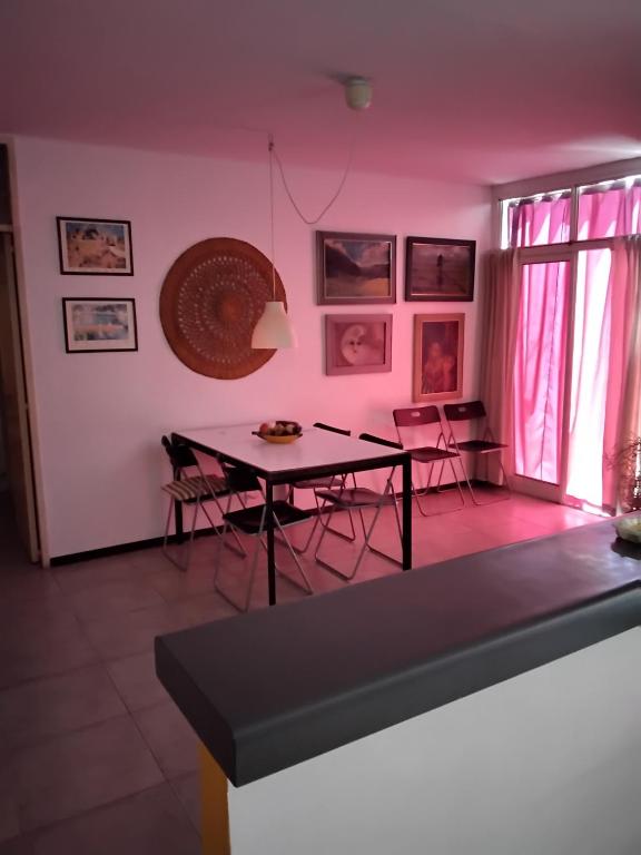 Maria Delicia في غودوي كروز: غرفة طعام مع طاولة وكراسي وجدران وردية