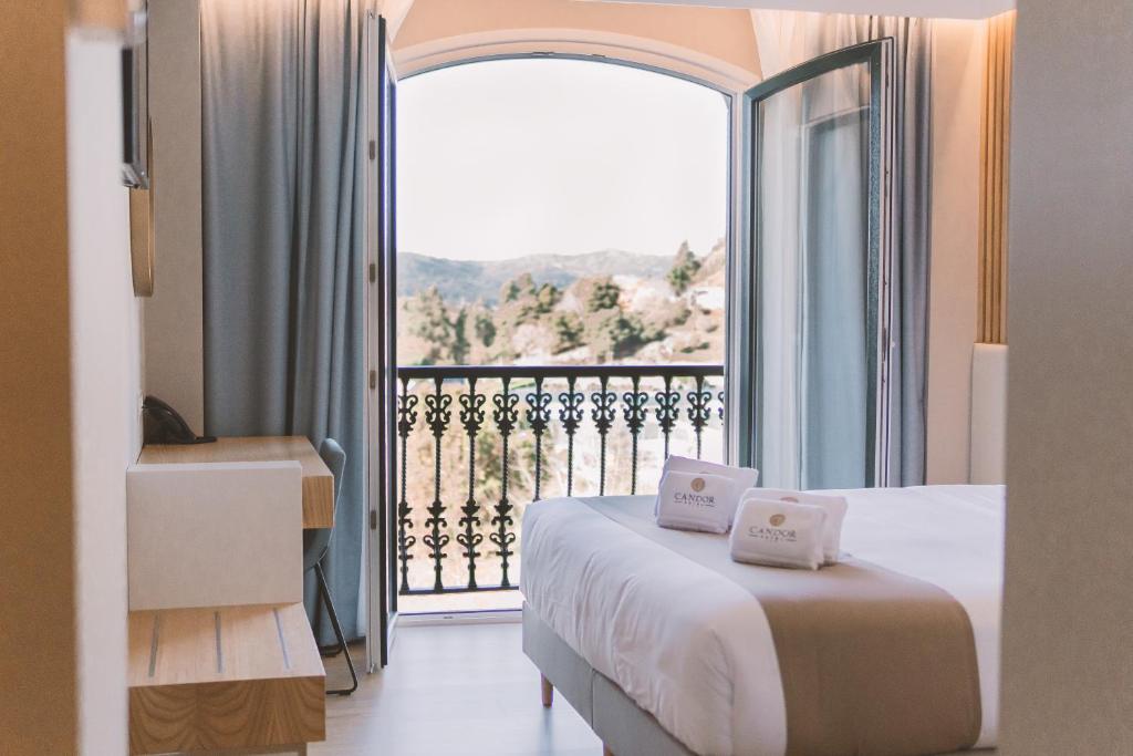 een slaapkamer met een bed en een groot raam bij HOTEL CANDOR in San Salvador