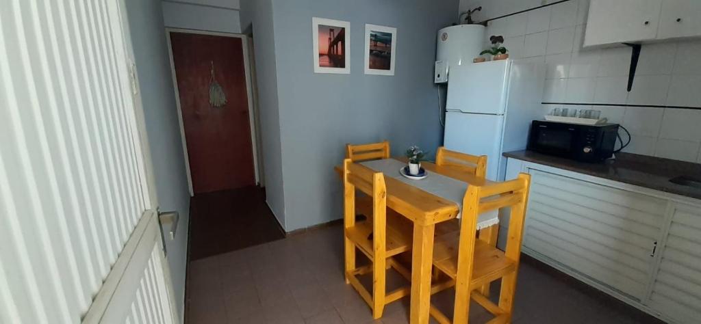 cocina con mesa, 2 sillas y nevera en Depto Temporario Centro Corrientes en Corrientes