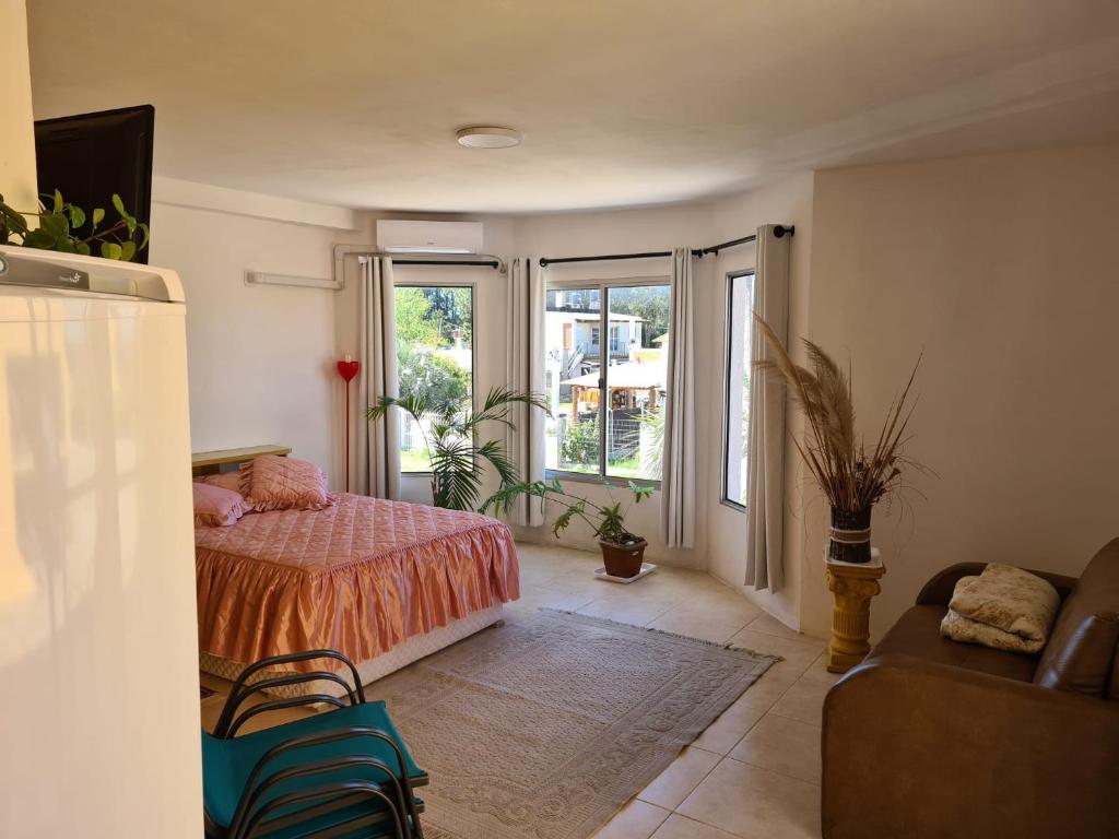 um quarto com uma cama, um sofá e janelas em Precioso apartamento a 1km de la playa. em Barra del Chuy