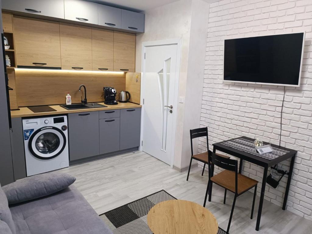 a kitchen and living room with a table and a microwave at Апартамент 3 А in Varna City