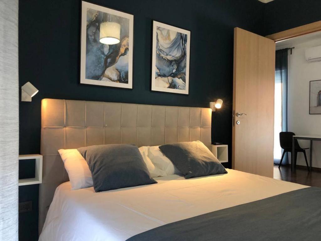 a bedroom with a large bed with two pictures on the wall at Blu Balena - appartamento piano attico con terrazze in Taranto