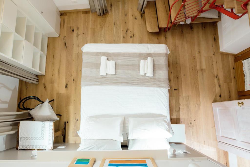 a bed in a room with wooden walls and white pillows at Home Dren in Prepotto