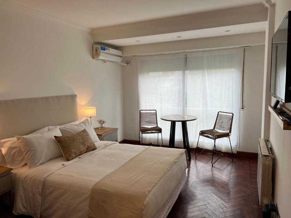 1 dormitorio con 1 cama, mesa y sillas en Alsina 728 con pileta UKIYO en Salta